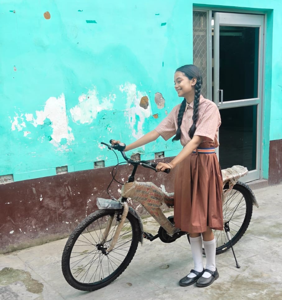 Shreyansi Bose standing with her new bicycle outside her school in Varanasi